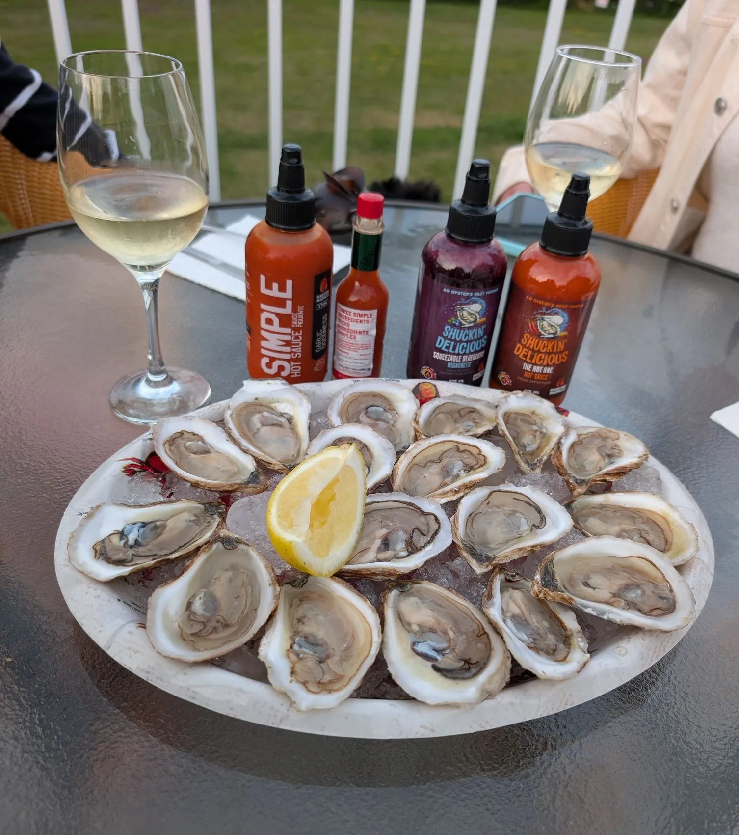 A platter of freshly shucked oysters with wine and hot sauces